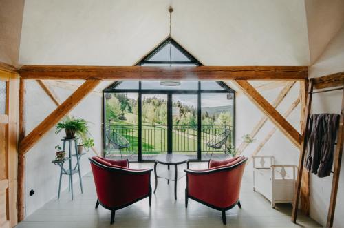 a dining room with a table and chairs and a large window at Gospodarstwo ekoturystyczne ARTYSTYKA in Bystrzyca Kłodzka