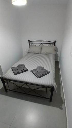 a bed with white sheets and towels on it at Harbor View Apartment Athens in Piraeus