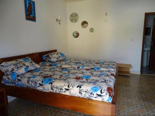 ein Schlafzimmer mit einem Bett mit blau-weißer Bettwäsche in der Unterkunft Sine Saloum in Fimela