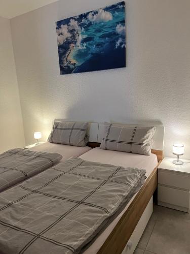 a bedroom with a large bed with two lamps on it at Ferienwohnung in Bochum