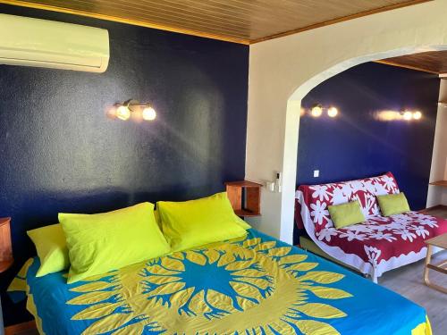 a bedroom with a bed and a chair in it at Atea Fare Pāmata'i in Faaa