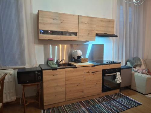 a kitchen with wooden cabinets and a sink and a stove at La Vie en Rose in Ensival