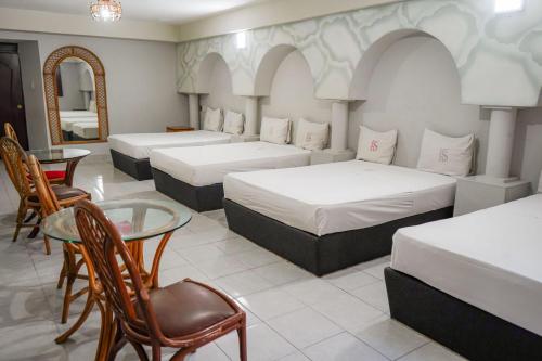 a room with three beds and a table and a mirror at Hotel Santander Veracruz in Veracruz