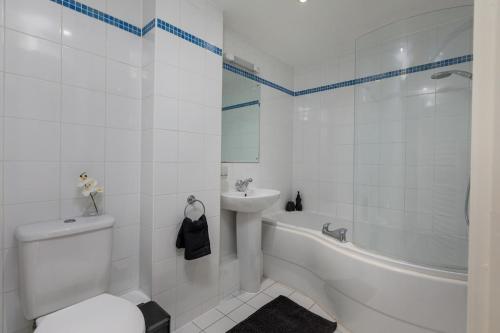 a bathroom with a toilet and a tub and a sink at The Midnight Parlour in Leeds