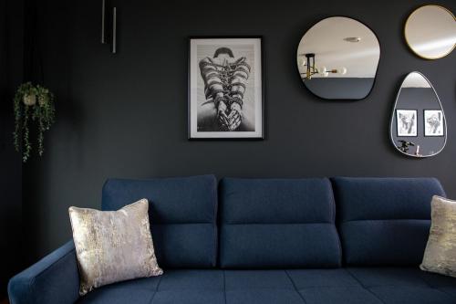 a living room with a blue couch and a mirror at The Midnight Parlour in Leeds