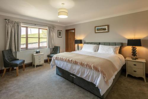 a bedroom with a bed and a chair and a window at Beaconsview B&B in Brecon