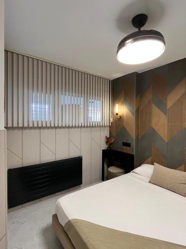 a bedroom with a white bed and a fireplace at Panorama Nacional in Ávila