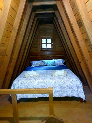 a bed in the attic of a log cabin at Chalé Premium com jacuzzi privativa Florianópolis in Florianópolis