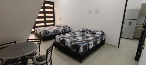 a room with two beds and a table and chairs at Villa Luna Hotel-Eventos in Carmen de Apicalá