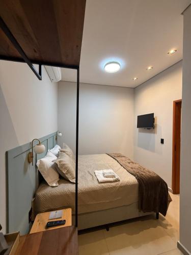 a bedroom with a bed and a table with a mirror at Hospedaria da Estação in Espirito Santo Do Pinhal