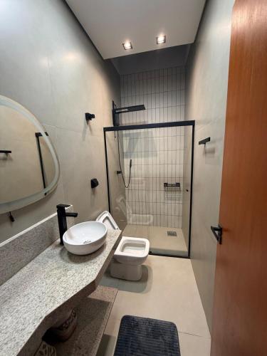 a bathroom with a shower and a toilet and a sink at Hospedaria da Estação in Espirito Santo Do Pinhal