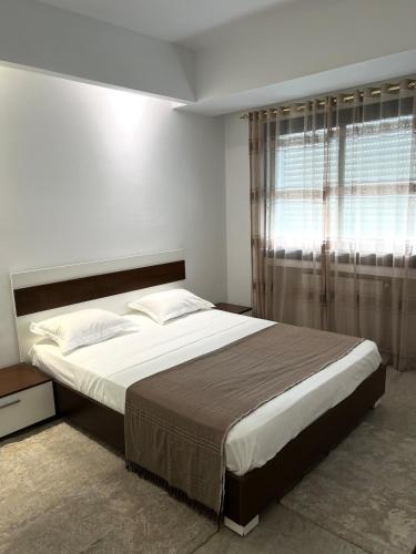 a bedroom with a large bed and a window at Comfortable and Fresh Apartment in Tunis