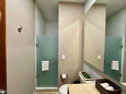 a bathroom with a toilet and a glass shower at Casa del Sol Lujoso Departamento en Acapulco in Acapulco