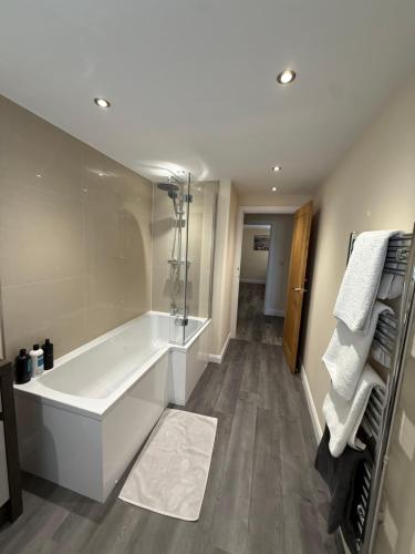 a white bathroom with a tub and a shower at Four Bedroom House With Private Pool - Stunning countryside location with parking close to Chester City Centre in Chester