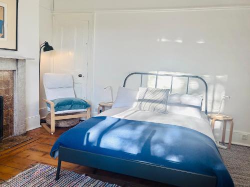 a blue bed in a room with a fireplace at Central Victorian House in London