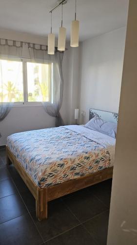 a bedroom with a bed in a room with a window at Lazy Wave Apartment in Torrevieja