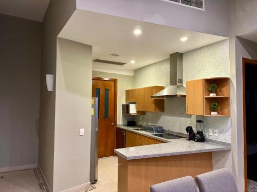 a kitchen with wooden cabinets and a counter top at Casa del Sol Lujoso Departamento en Acapulco in Acapulco