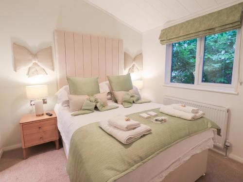 a bedroom with a bed with two towels on it at Unique Luxury Lodge in Windermere