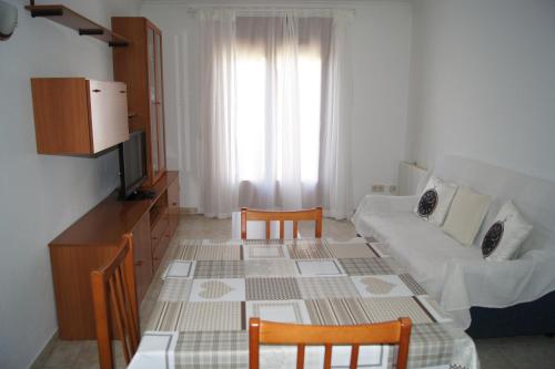 sala de estar con sofá, mesa y sillas en Barceloneta UPartments, en Figueres