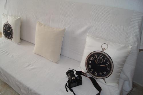 a clock sitting on top of a bed with pillows at Barceloneta UPartments in Figueres