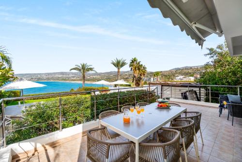 a table and chairs on a balcony with a view of the ocean at Beachfront Villa Mare with Jaccuzi and Infinity Pool in Kissonerga