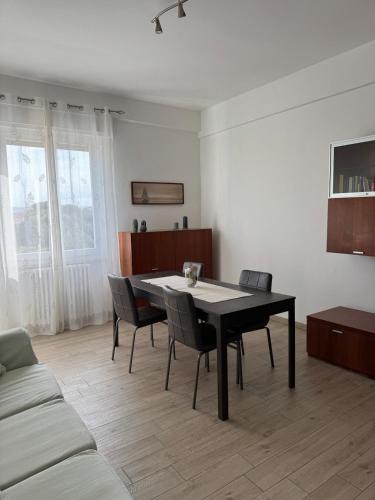 a dining room with a black table and chairs at Le Casette di Elfo in Grosseto
