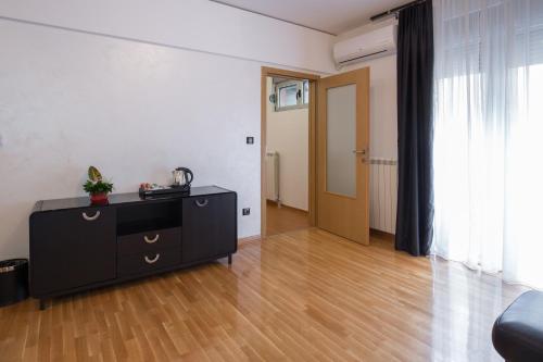 a living room with a black dresser and a door at Nova City Garni Hotel Signature Collection in Belgrade