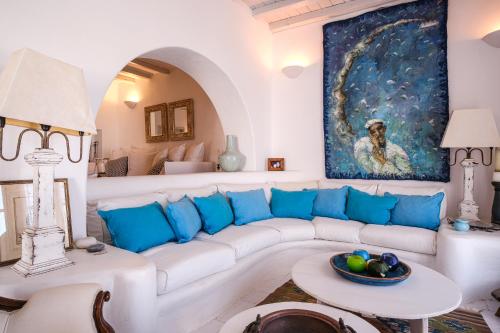 a living room with a white couch and a painting at Elegance Villa in Platis Gialos