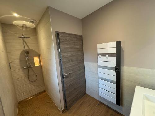 a bathroom with a shower and a glass door at Le Buchon Lodge in Montcornet