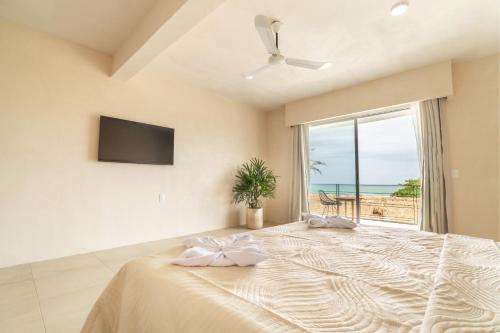 a bedroom with a large bed with a view of the ocean at Casa Nami in Puerto Escondido