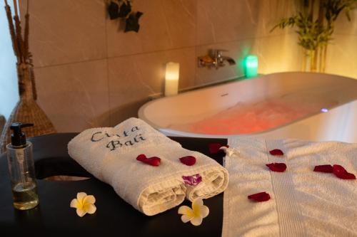 two towels on a table next to a bath tub at Suite Climatisé Bali SPA et sauna privé pour 2-Châteaux de la Loire in Cour-Cheverny