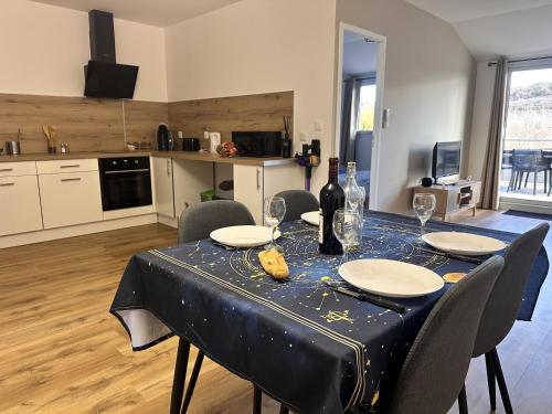 a dining room table with a blue table cloth and wine glasses at L'abeille sous les étoiles in Saint-Michel-lʼObservatoire