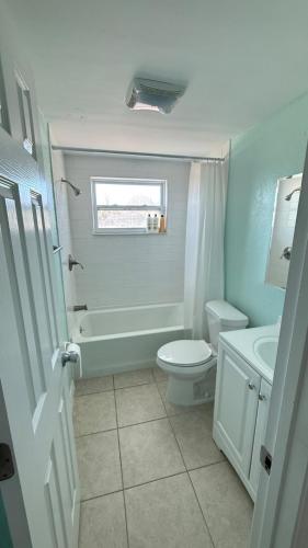 a bathroom with a toilet and a tub and a sink at Modern 3BR Home in secure neighborhood with Free Parking & WiFi in Riverview