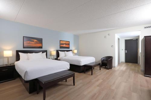 a hotel room with two beds and two chairs at Canad Inns Health Sciences Centre in Winnipeg