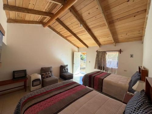 a bedroom with two beds and a chair in a room at Hotel Mi Lindo Chihuahua in Areponapuchi