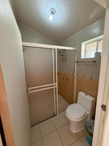 a bathroom with a toilet and a glass shower at Hotel Mi Lindo Chihuahua in Areponapuchi
