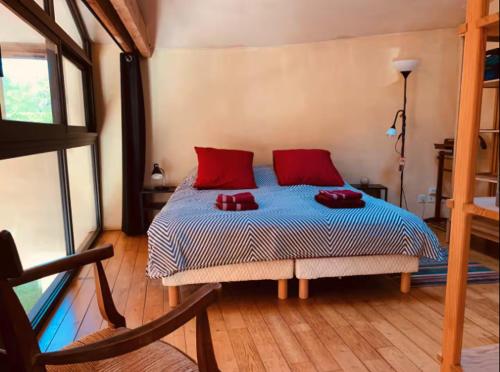 a bedroom with a bed with red pillows on it at Ferme de Jeanleix in Sauxillanges