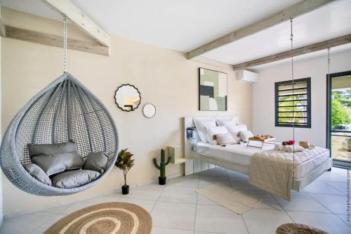 a room with a swinging bed and a couch at Résidence Les A'Rhum de l'Anse in Les Trois-Îlets