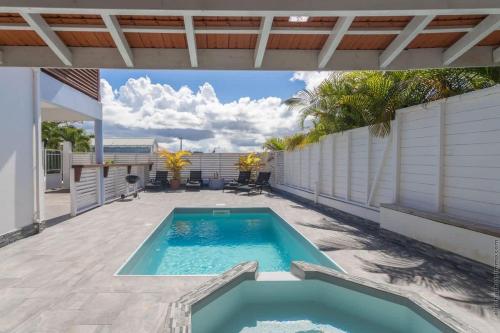 a swimming pool on the patio of a house at Villa 2 chambres, Jacuzzi et Piscine in Maximin