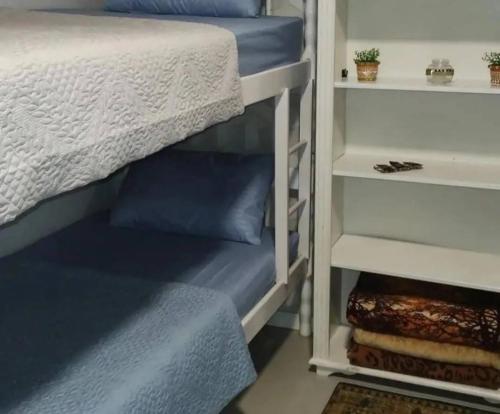 a bedroom with a bunk bed with blue sheets at Hostel SIL CARDOSO in Blumenau