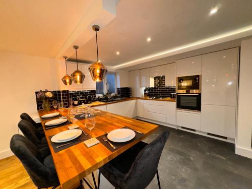a kitchen with a wooden table and black chairs at Modern Central St Albans Maisonette Free Parking Sleeps 4 Fast Wifi in St. Albans