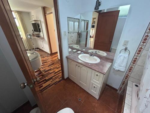 a bathroom with a sink and a mirror at Villa Salluzzi Apart Hotel in Tacna