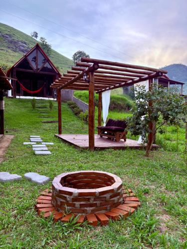 a pergola and a fire pit in a yard at Chalé Sertão da Boa Vista in Rio Claro