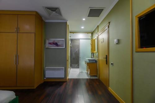 a room with a hallway with a bathroom and a sink at LUVERDE HOTEL Sarkand in Almaty