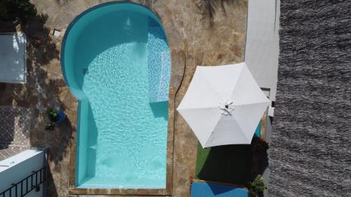 a white umbrella sitting next to a swimming pool at Palm Residence Vacation Villa in Nungwi