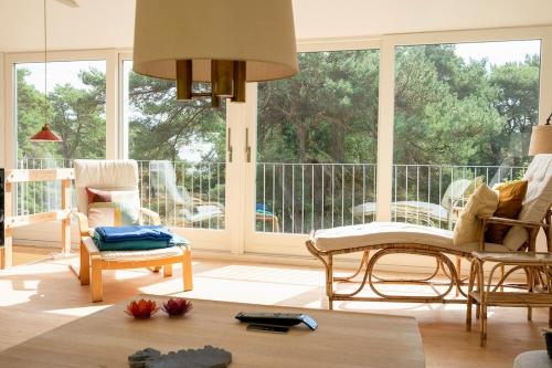 a living room with chairs and a large window at Red Stone House By Dueodde Beach in Neksø