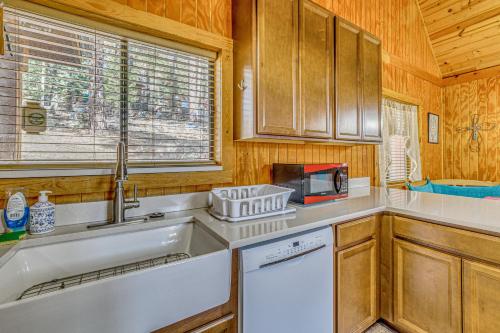 a kitchen with a sink and a microwave at Peaceful & Private Cloudcroft Cabin with Deck! in Cloudcroft