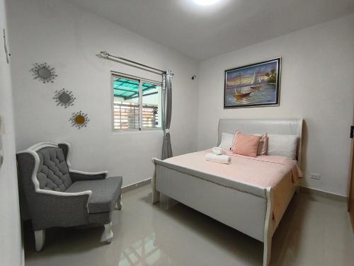 a bedroom with a bed and a chair and a window at América Colares VII in Los Frailes