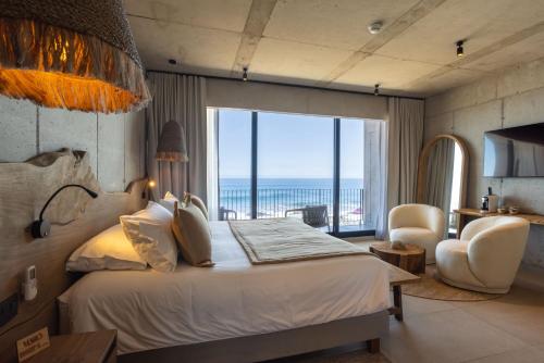 ein Schlafzimmer mit Bett und Meerblick in der Unterkunft Hotel Maró in Pichilemu