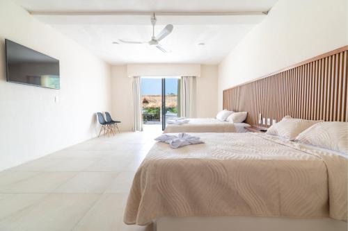 a bedroom with two beds and a ceiling fan at Casa Nami in Puerto Escondido
